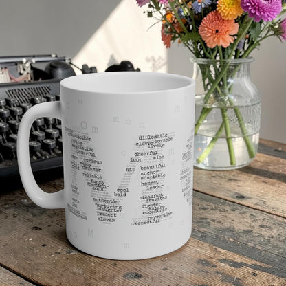 White mug with text design on a wooden table with flowers and a typewriter in the background