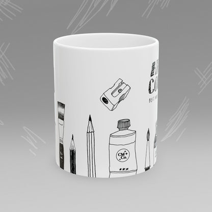 White mug with black text and illustrations of art supplies