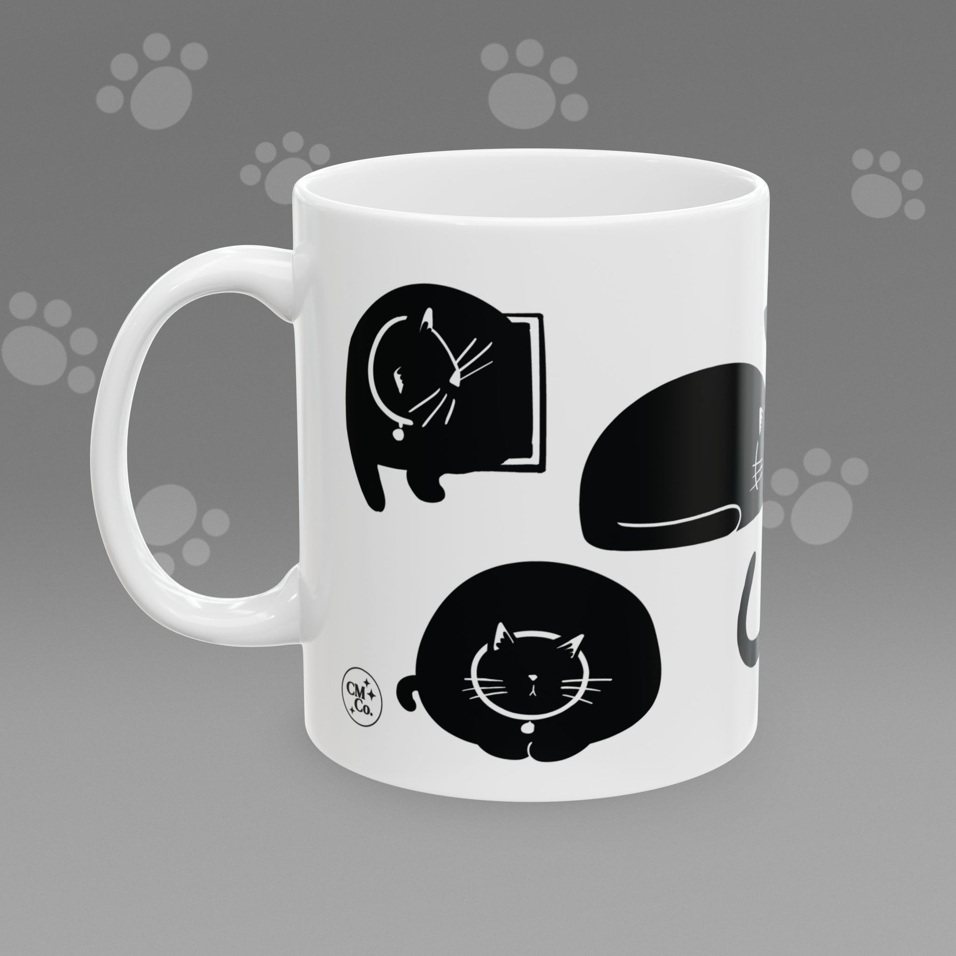 Coffee mug with fat black cat illustrations on a gray background
