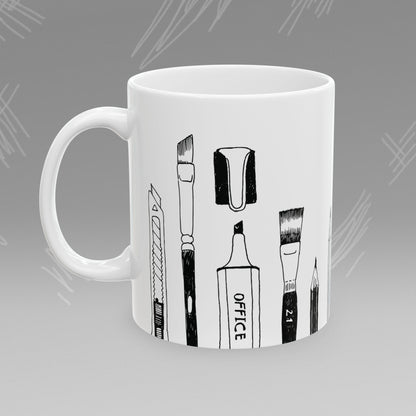 White mug with black text and illustrations of art supplies