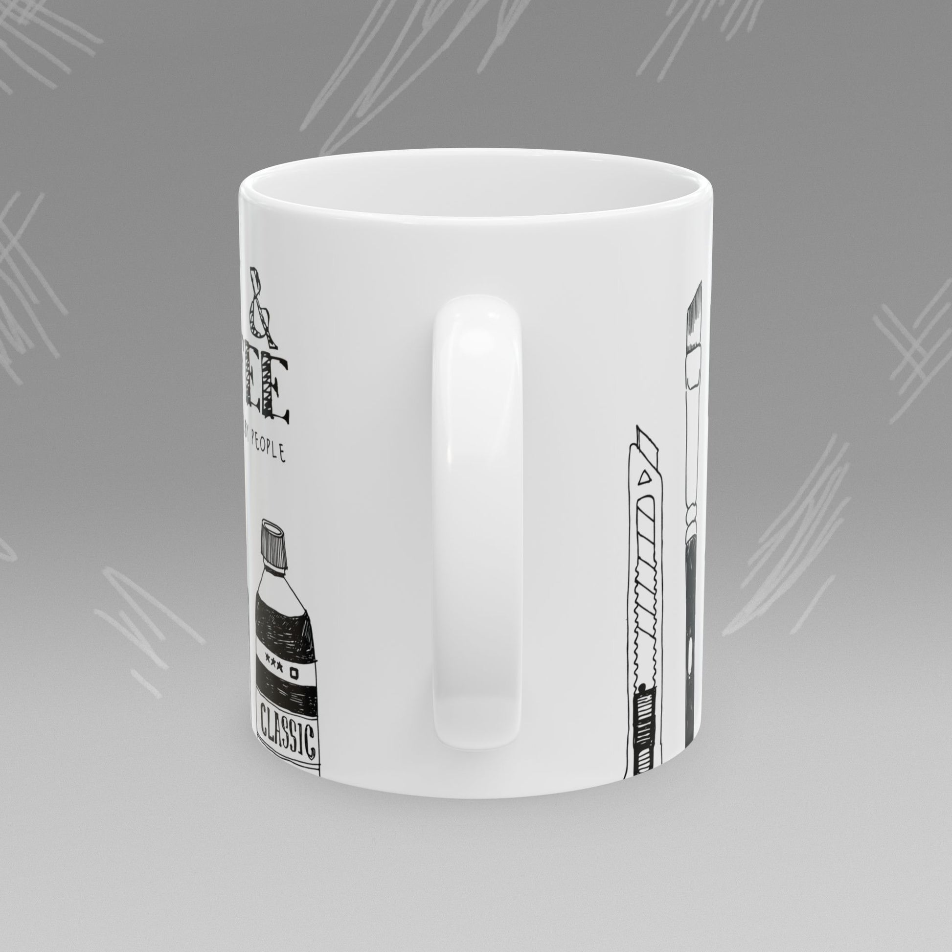 White mug with black text and illustrations of art supplies