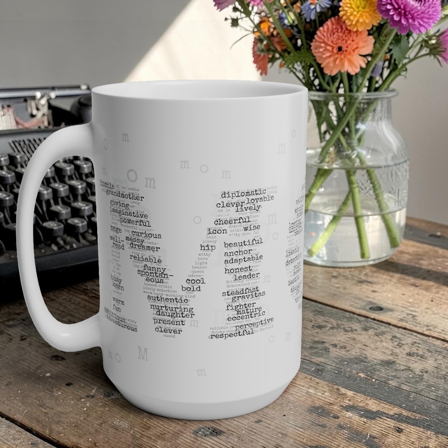 White mug with text on a wooden surface with flowers and a typewriter in the background