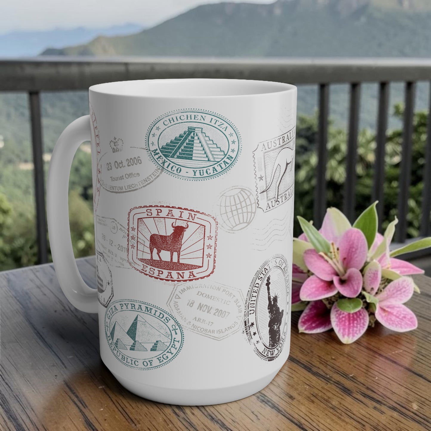 White mug with travel-themed designs on a wooden table with a scenic 